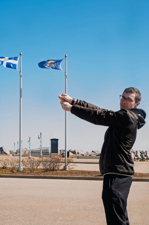 A man in black sportswear stands and holds a flag.の写真素材