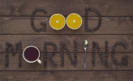Good morning. Text made up of cereal rings, oranges, cup and spoon.の写真素材