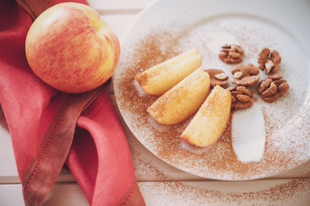 An apple is sliced into wedges and cored using a handy kitchen tool.の写真素材