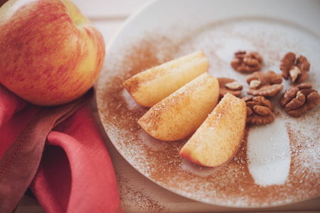 An apple is sliced into wedges and cored using a handy kitchen tool.の写真素材