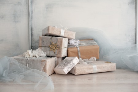 Wrapped gift boxes with silver Christmas ornaments.