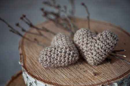 Two knitting hearts on old wooden panel. Background Valentines Day.Valentines day cards.の写真素材