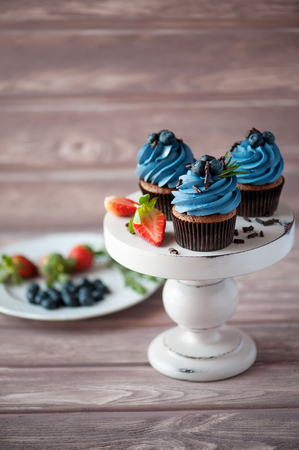 three ?upcake with blueberry cream on circle plateの写真素材