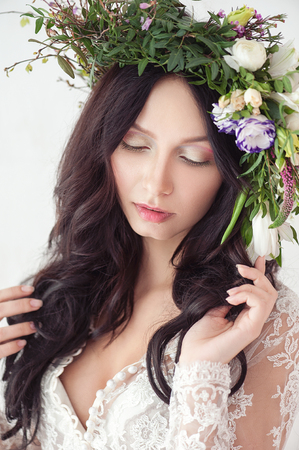 Beauty Fashion Portrait. Beautiful Woman with Curly Hair, Makeup and Flowers Wreathの写真素材