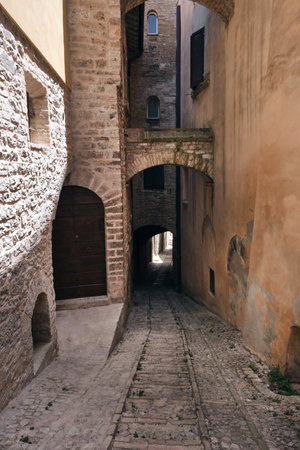 alley with arches in the medieval town of spello umbriaの写真素材