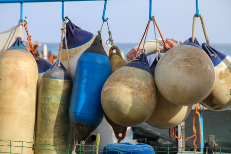 Used Buoy fenders or boat bumper blue and white drying under the sun. Italy