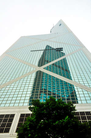 Skyscraper reflected over the facade of a modern glass and steel offices building