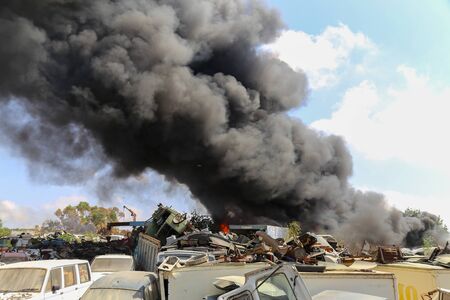 Big column of smoke coming from a burning cars