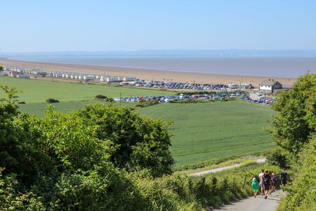 Tourists walking on the hill of Brean Down with the view of the Brean Beach, Somerset, Englandの写真素材