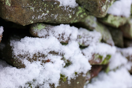 Old Wall stone covered in snow. Close-up, focus on the foregroundの写真素材