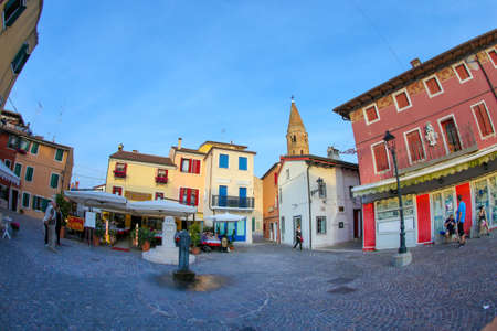 General view of the typical Italian square with bar and restaurants in Caorle with facade of...