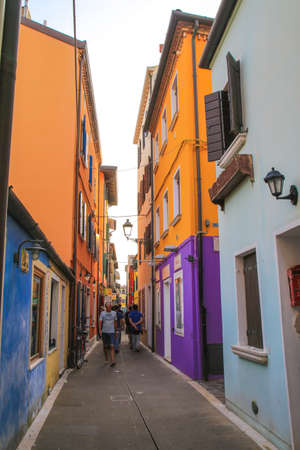 General view of the typical Italian narrow street in Caorle with facade of colourful buildingsのeditorial素材