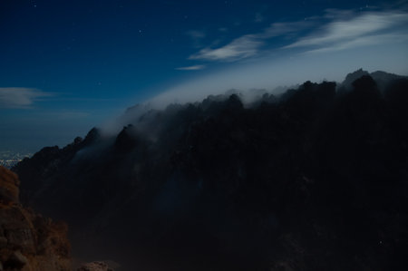 Night view of smoke from Merapi Volcano coming out of the rocks in black silhouetteの写真素材