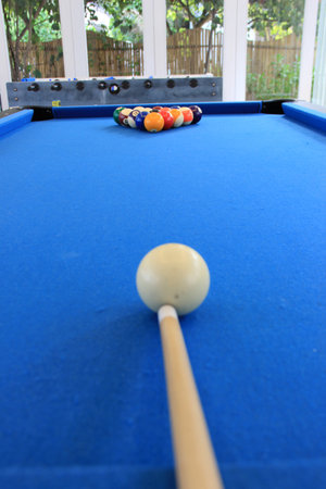 Motion blurred billiard balls with numbers on them on a blue pool table