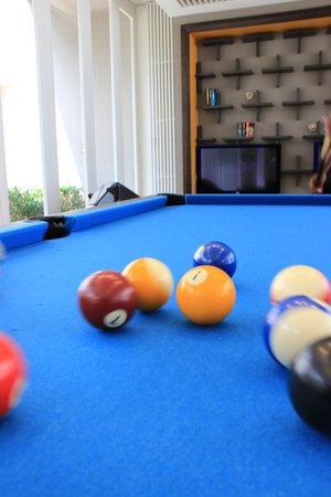 Motion blurred billiard balls with numbers on them on a blue pool tableの写真素材