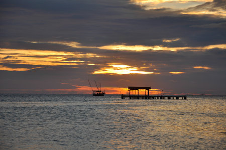 Water surface. View of a Sunset sky background. Dramatic gold sunset sky with evening sky clouds over the sea. with a Platform.の写真素材