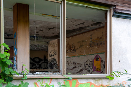 old window with graffiti on the wall of a building in the cityの写真素材