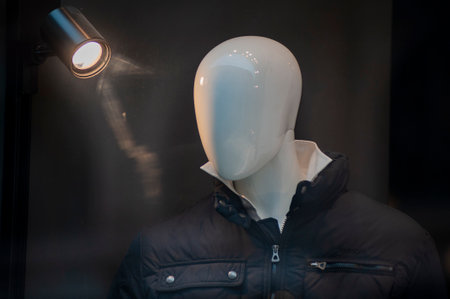 Mannequin wearing a black jacket in a fashion store window.の写真素材