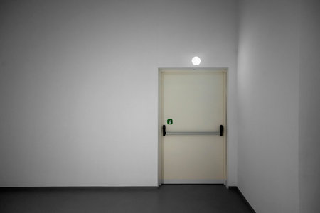 White door in a room with a light coming through the door.