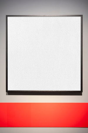 A black rectangular frame with a white interior on a gray wall. A red band runs horizontally at the bottom. The frame leaves room for text or images.の写真素材