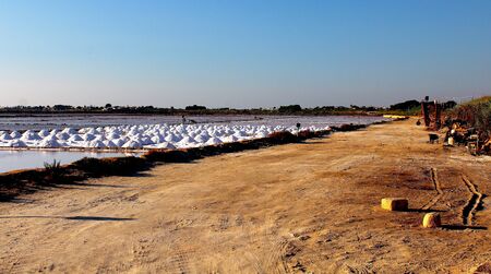 Stagnone Nature Reserve or natural reserve of the 'Saline dello Stagnone' near Marsala and Trapani, Sicily, Italy, heaps of salt near the salt flats at sunsetの写真素材