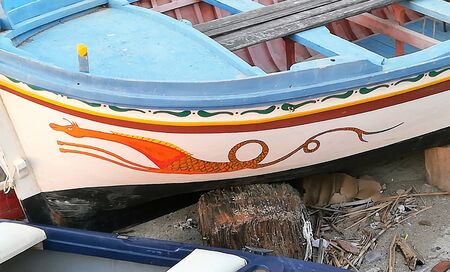 evocative image of the side of a fishing boat with a painted dragonの写真素材