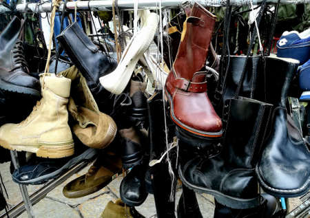 evocative image of men's shoes at a vintage market: amphibians, boots, ankle boots, sneakersのeditorial素材