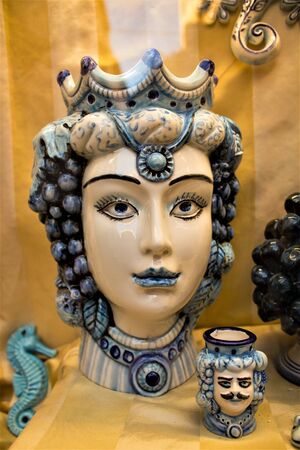 Dark brown heads and pinecones of blue ceramic of handmade production Sicilian to promote the Sicily region in Italyの写真素材