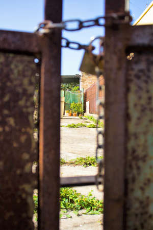 evocative image of part of rusty gate with chain and lockの写真素材
