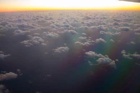 evocative image of a sunrise from an airplane in flight with the sun rising on the horizon with...