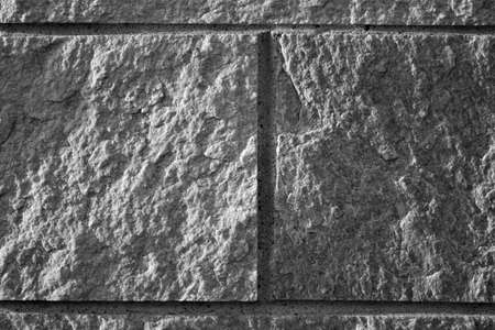 evocative black and white image of granite wall with joints between tiles