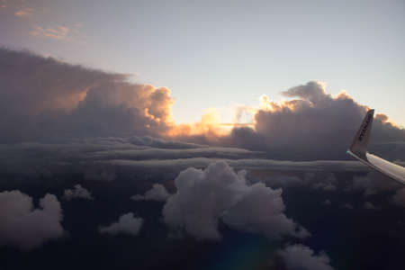 spectacular sunset seen from an airplane with clouds in the foreground and in the distance