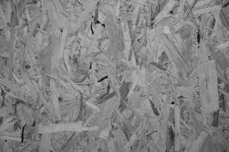 evocative black and white image of wood chipboard wall texture of various shapesの写真素材