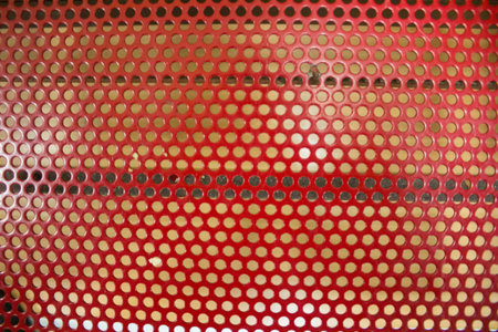 evocative image of red colored iron surface texture with cylindrical holesの写真素材
