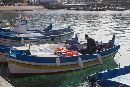 evocative image of fishing boats moored in the harbor in a small fishing village in Sicily, Italyの写真素材