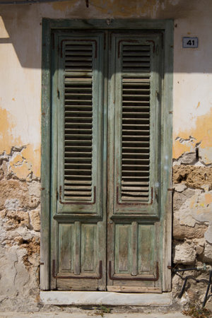 evocative image of an old closed shutter of a houseの写真素材