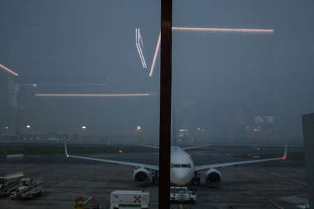 evocative image of the reflection of neon lights on an airport window