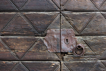 Detail of an old wooden doorway with metal lock and knockerの写真素材