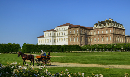 Venaria Reale, Piedmont region, Italy. June 2017. The landscape of the gardens of the royal palace of Venaria. View from the gardens towards the palace. A beautiful carriage crosses the gardens.のeditorial素材
