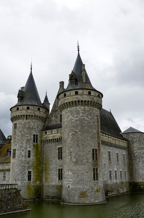 Castle of Sully-sur-Loire, Loire region, France. Snap of 30 June 2017 17:38. Shooting from the park towards the castle entrance. The faÃ§ade is mirrored in the water of the moat. Sky with stormy cloudsのeditorial素材