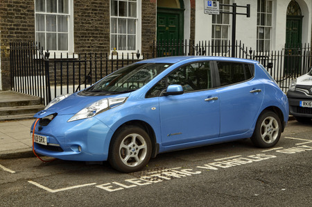 London, United Kingdom, June 2018. A Nissan Leaf parked in the historic center of London. The parking lot is reserved for electric vehicles and is equipped with a quick charging column.のeditorial素材