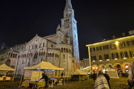 Modena, Emilia Romagna, Italy. December 2018. Piazza Maggiore is the center of the city. The clock tower and the cathedral are characteristic elements of the square. The dark lights up the Christmas lights.のeditorial素材