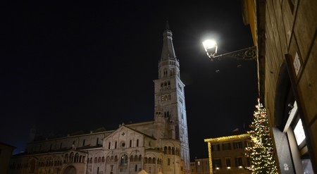 Modena, Emilia Romagna, Italy. December 2018. Piazza Maggiore is the center of the city. The clock tower and the cathedral are characteristic elements of the square. The dark lights up the Christmas lights.のeditorial素材