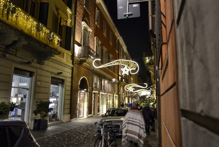 Modena, Emilia Romagna, Italy. December 2018. Night view of the streets of the historic center. The Christmas atmosphere is underlined by the bright decorations. People stroll enjoying the place.のeditorial素材