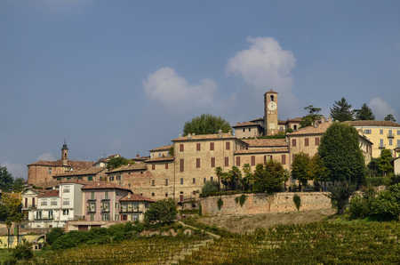 Neive, Italy. October 2018. Going up towards the village the view is enchanting: on the top of the hill the inhabited center, the clock tower stands out, at the foot the magnificent vineyards.のeditorial素材