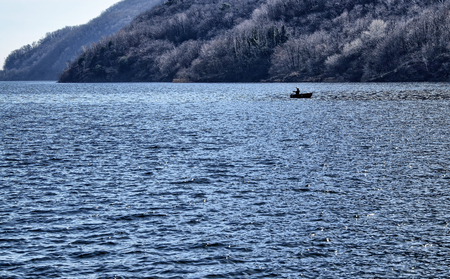 Mergozzo, Piedmont, Italy. March 2019. A fisherman with his boat in the middle of the lake.のeditorial素材