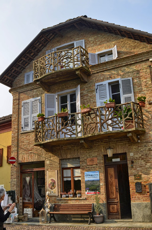Neive, Piedmont, Italy. October 2018. A house in the historic center with particular balconies. On the ground floor a craft shop of yarns and curtains, on the back a restaurant with a panoramic terrace.のeditorial素材