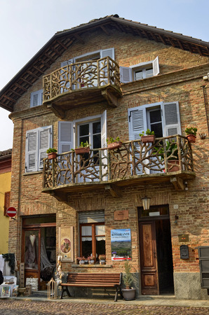 Neive, Piedmont, Italy. October 2018. A house in the historic center with particular balconies. On the ground floor a craft shop of yarns and curtains, on the back a restaurant with a panoramic terrace.のeditorial素材