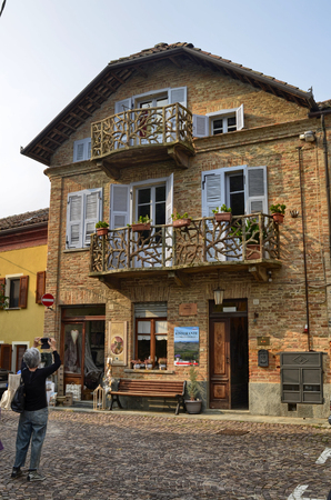 Neive, Piedmont, Italy. October 2018. A house in the historic center with particular balconies. On the ground floor a craft shop of yarns and curtains, on the back a restaurant with a panoramic terrace.のeditorial素材