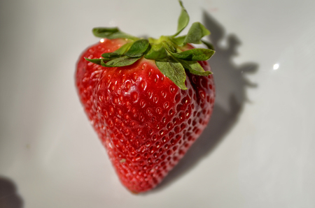 A white plate with bright red strawberries.の写真素材